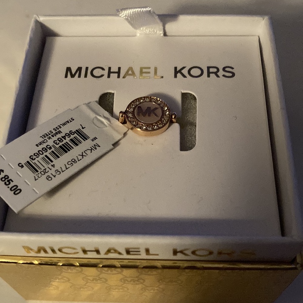 Michael Kors pink enamel/rose gold color round “MK” logo ring.